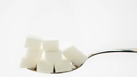 Pile-of-sugar-lumps-appearing-on-teaspoon