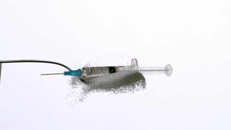 Syringe-falling-onto-spoon-of-sugar