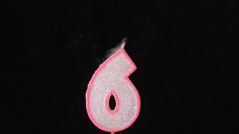 Six-birthday-candle-flickering-and-extinguishing-on-black-background
