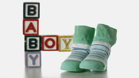 Slippers-falling-besides-baby-blocks-on-white-background