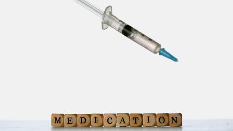 Syringe-falling-in-front-of-dice-spelling-medication