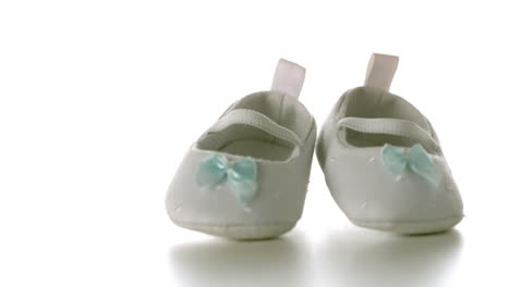 White-baby-shoes-falling-on-white-surface