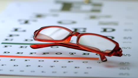 Gafas-De-Lectura-Cayendo-Sobre-La-Prueba-De-La-Vista