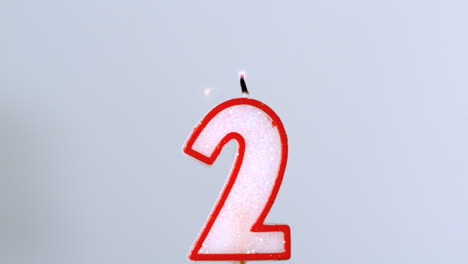 Two-birthday-candle-flickering-and-extinguishing-on-blue-background