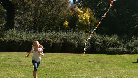 Little-girl-running-after-her-brother-playing-with-a-kite