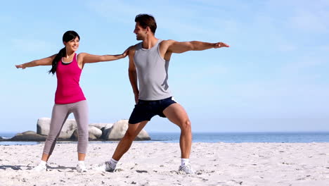 Mujer-Y-Su-Entrenador-Estirándose-En-La-Playa.