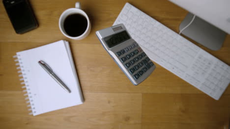 Pocket-calculator-falling-onto-office-desk