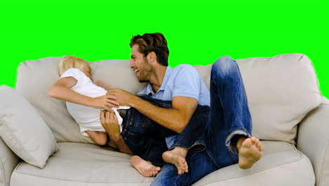 Father-tickling-son-on-the-sofa-on-green-screen