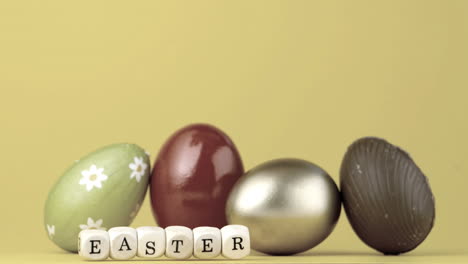 Dice-spelling-out-easter-falling-in-front-of-four-easter-eggs