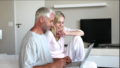 Couple-using-laptop-together-and-chatting