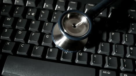 Stethoscope-falling-onto-computer-keyboard-and-bouncing