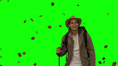 Cheerful-man-standing-under-leaves-falling-on-green-screen