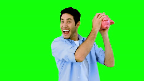 Man-shaking-piggy-bank-excitedly-on-green-screen