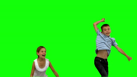 Brother-and-sister-jumping-together-on-green-screen