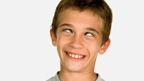 Little-boy-squinting-against-white-background