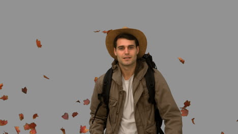 Man-walking-under-leaves-falling-on-grey-screen