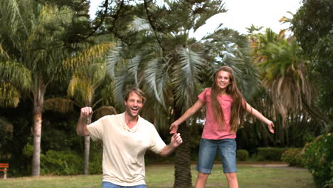 Smiling-daughter-jumping-on-a-trampoline-with-her-father-