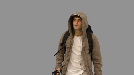 Attractive-man-with-a-coat-trekking-on-grey-screen
