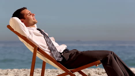 Hombre-De-Negocios-Sonriente-Relajándose-En-La-Playa