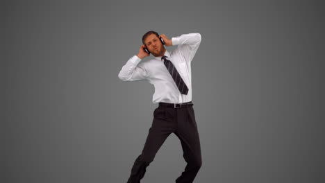 Businessman-jumping-and-listening-to-music-on-grey-background