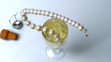 String-of-pearls-dropping-in-glass-of-champagne