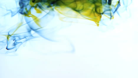 Yellow-and-blue-ink-swirling-in-water-on-white-background