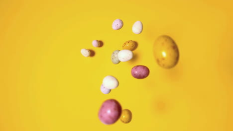 Easter-eggs-falling-on-yellow-surface