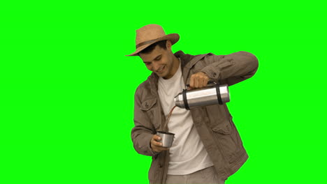 Man-pouring-coffee-from-a-vacuum-flask-on-green-screen