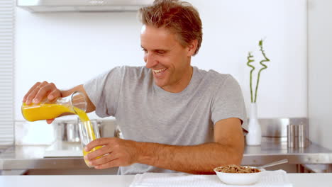 Mann-Gießt-Orangensaft-In-Sein-Glas