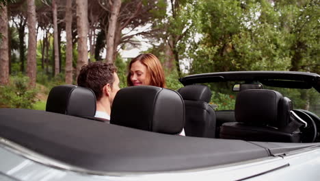 Beautiful-young-couple-kissing-in-a-convertible-car-