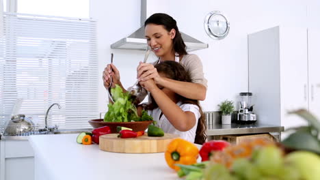 Mother-and-daughter-tossing-salad-together