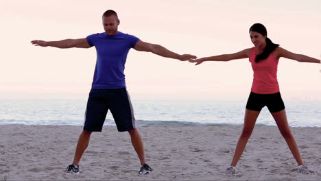 Freunde-Dehnen-Sich-Gemeinsam-Am-Strand