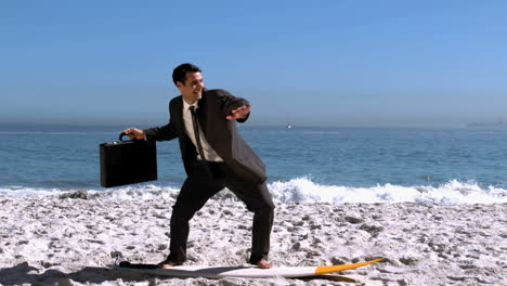 Smiling-businessman-balancing-on-a-surfboard-