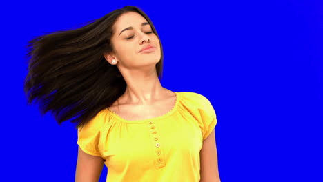 Smiling-woman-tossing-her-hair-on-blue-screen