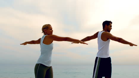 Man-and-woman-doing-pilates-on-beach