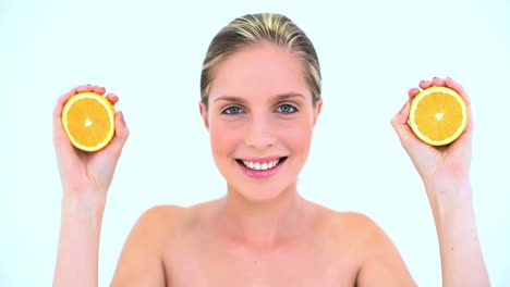 Blond-woman-holding-two-slices-of-orange