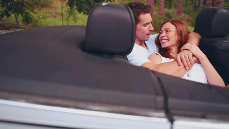 Man-kissing-his-girlfriend-in-a-convertible-car