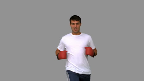 Handsome-boxer-performing-a-high-kick-on-grey-screen