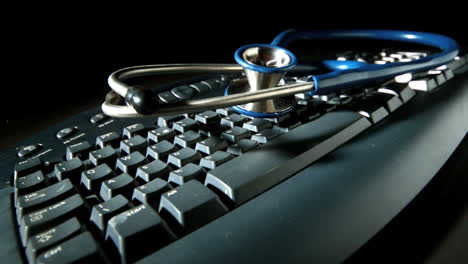 Blue-stethoscope-bouncing-after-fall-onto-computer-keyboard-