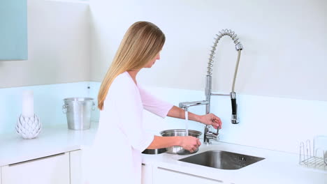 Blonde-woman-filling-water-on-saucepan