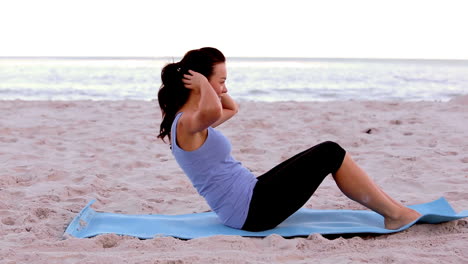 Woman-doing-sit-ups-on-the-beach