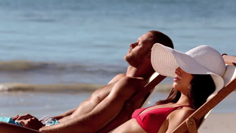 Couple-tanning-on-the-beach