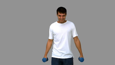 Attractive-man-lifting-dumbbells-on-grey-screen