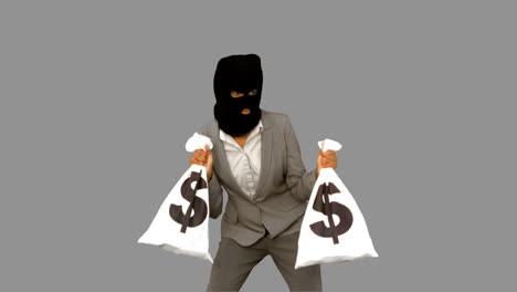Burglar-wearing-balaclava-and-holding-money-bags-on-grey-screen