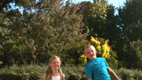 Happy-siblings-jumping-together-in-their-garden