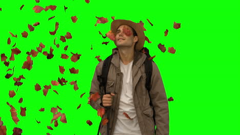 Man-standing-under-leaves-falling-on-green-screen