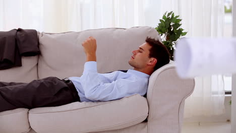 Tired-businessman-using-his-tablet-on-a-couch