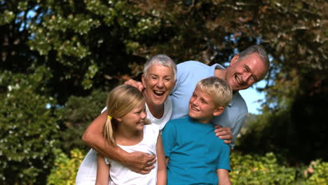 Fröhliche-Mehrgenerationenfamilie-Umarmt-In-Einem-Park