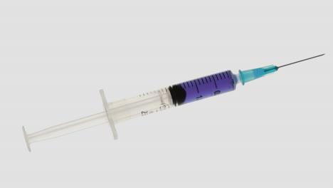 Focus-on-syringe-holding-blue-liquid