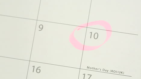 Man-circling-mothers-day-on-calendar-and-laying-down-tulip